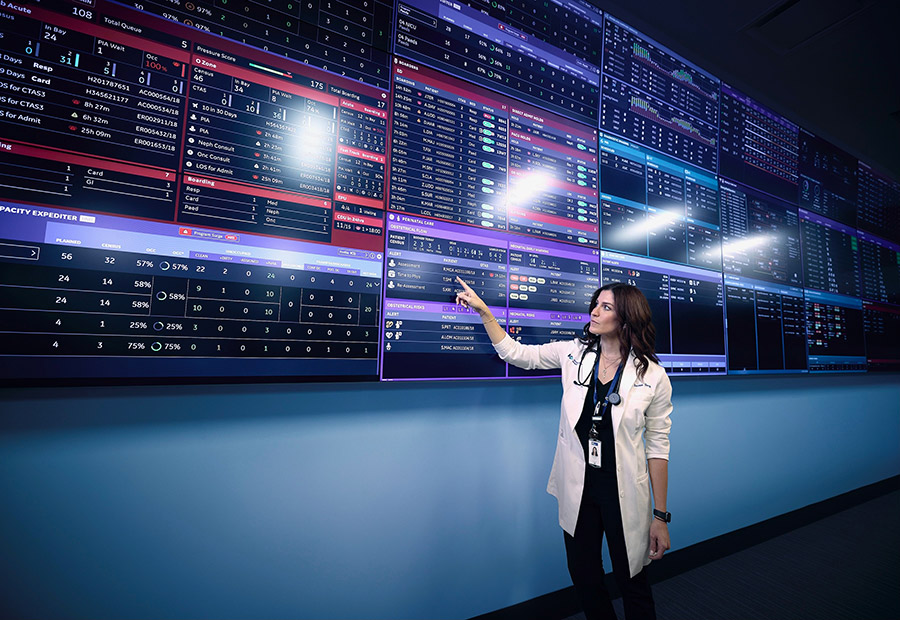 Chief of Medicine pointing to data on a digital screen in the Command Centre at Humber River Health